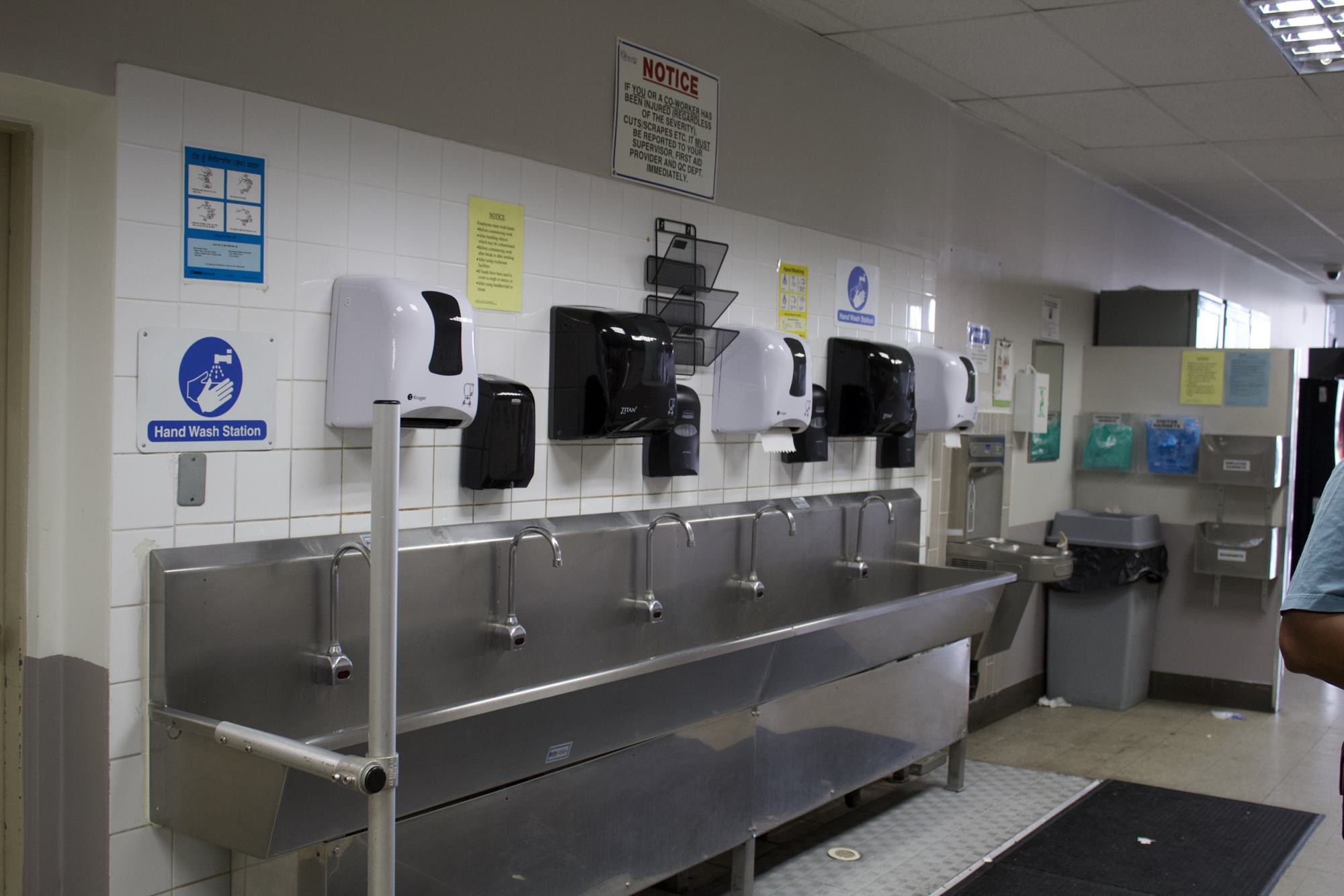 Stainless steel multi-station hand wash trough at a plant entrance